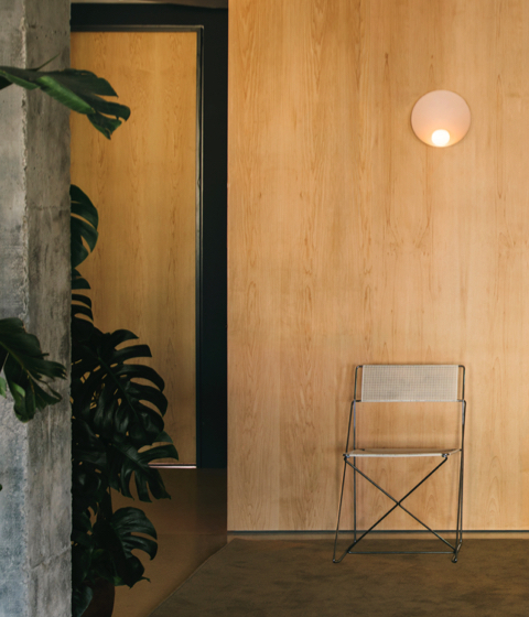pale pink circular wall light in a beautiful wooden hallway