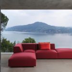 Red modular sofa in a living room with a beautiful view of a lake