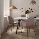 pink and apricot dining chairs white marble table with a gold pendant light