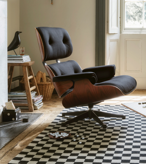 comfortable Eames lounge chair in cherry walnut and black leather